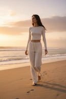 Modelo feminina calça linho off-white praia pôr do sol